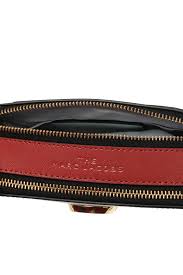 Close-up of a red handbag with gold accents on a white background